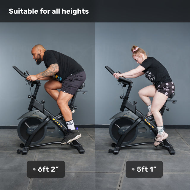 A 6'2" man and a 5'1" woman ride Bells of Steel Blitz Indoor Cycling Bikes side by side, showing the adjustable handlebars and smooth magnetic resistance system. Text reads “Suitable for all heights.”.
