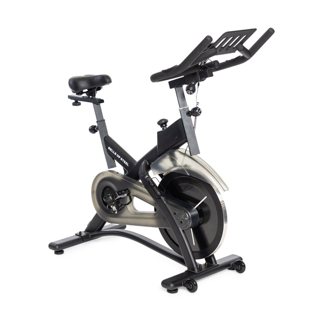 Introducing the Bells of Steel Blitz Indoor Cycling Bike, a modern stationary exercise bike featuring an adjustable seat and handlebars. Its sleek black design includes a large flywheel, magnetic resistance, and a compact digital display—perfect for dynamic indoor cycling workouts.