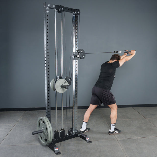A man in athletic wear uses the Bells of Steel Fat Bar - Tricep Pressdown with a cable machine and weight plates to perform triceps pushdowns, enhancing grip strength in a gym.