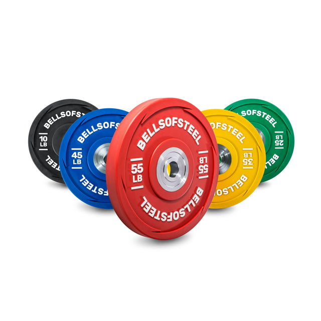 The Bells of Steel Urethane Bumper Plate Sets are arranged in staggered colors: red (55 lb), blue (45 lb), yellow (35 lb), green (25 lb), and black (10 lb). Ideal for Olympic weightlifting, they feature "BELLS OF STEEL" in white.