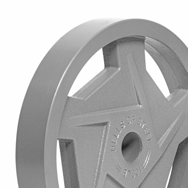 A close-up of the Gray Mighty Grip Olympic Weight Plate from Bells of Steel showcases a star design with "BELLS OF STEEL" engraved around the center hole. The textured surface and hammertone powder coat finish enhance its ergonomic design for a superior grip.
