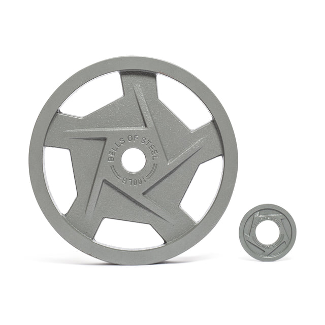 Two ergonomically designed Gray Mighty Grip Olympic Weight Plates by Bells of Steel are displayed on a white background. The larger gray plate has a star in the center with "BELLS OF STEEL" inscribed, while the smaller plate beside it mirrors its design.