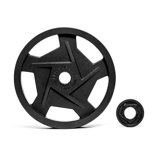 On a white background, two Bells of Steel Black Mighty Grip Olympic Weight Plates are displayed: the larger featuring a star design with five spokes and ergonomic grip handles; the smaller is solid. Both plates are embossed with text.