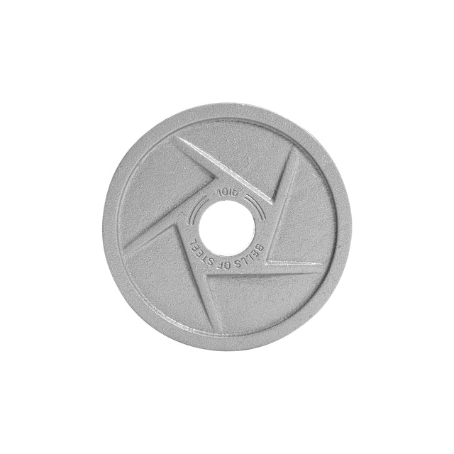 The image displays a close-up of a round, silver Gray Mighty Grip Olympic Weight Plate by Bells of Steel. The plate, featuring "BELLS OF STEEL" embossed text, has angular grooves radiating from the center and is coated in a durable hammertone powder finish.