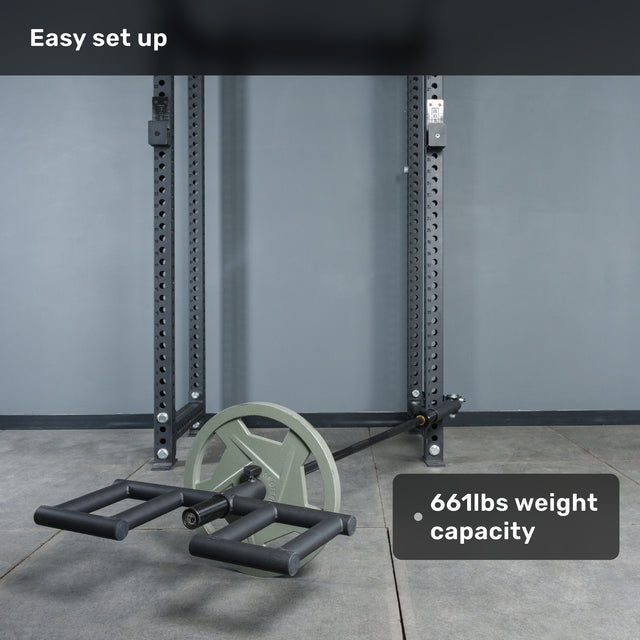 A Bells of Steel Viking Press Attachment with handles and large wheels is set up on a squat rack next to a landmine in a gym. The image displays the text "Easy set up" and "661lbs weight capacity.