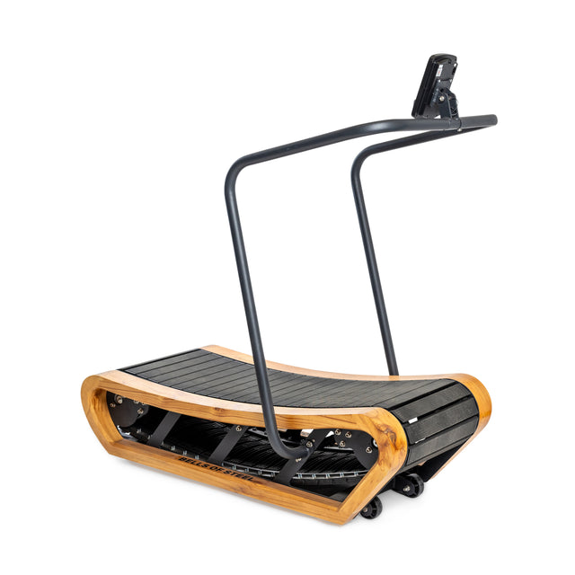 The Bells of Steel Wooden Residential Manual Treadmill is a curved, self-powered treadmill with a wooden frame, black running surface with impact-absorbing slats, a simple black handlebar, and a small top-mounted display screen.