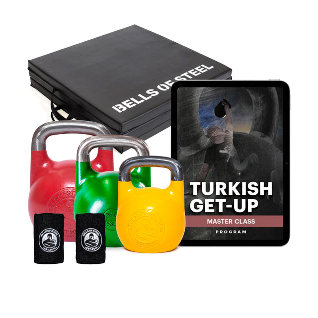 Introducing the vibrant Wildman Turkish Get Up Kettlebell Bundle by Bells of Steel, featuring red, green, and yellow kettlebells with black wrist wraps. Enhance your routine with Mark Wildman's master class on your iPad, all in chic black boxes.