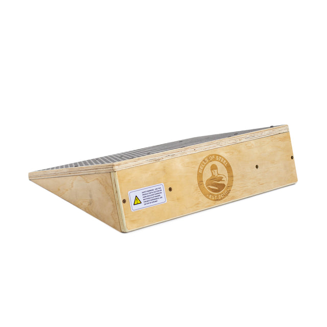 The Bells of Steel Squat Wedge Board features a grated metal top, side logo, and caution label. Its angled wooden design boosts ankle mobility, making it perfect for exercise or physical therapy.