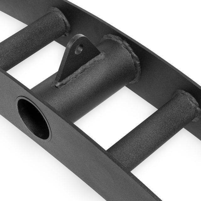 Close-up of the Bells of Steel Arch Nemesis Tricep Bar, featuring textured cylindrical grips, a central circular opening, and a welded triangular bracket for cable attachment. Its matte black metal finish underscores its durable design.