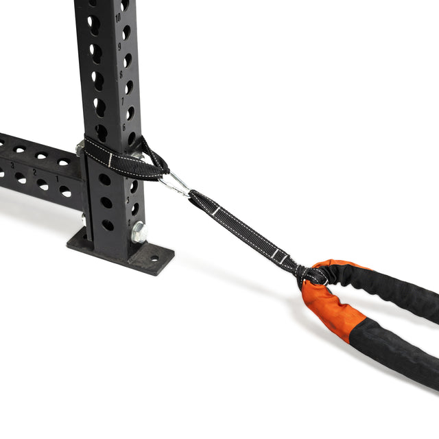 A Bells of Steel Battle Rope is attached to a black metal exercise rack via carabiner. The rope has a stylish black and orange sleeve, perfect for conditioning workouts akin to intense battle ropes sessions.
