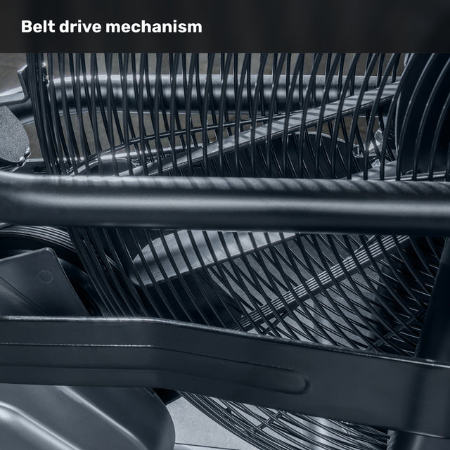 Close-up of the Blitz Air Bike’s belt drive mechanism by Bells of Steel, featuring interwoven black belts and metal components that highlight its intricate commercial-grade design. The top text reads, "Belt drive mechanism.