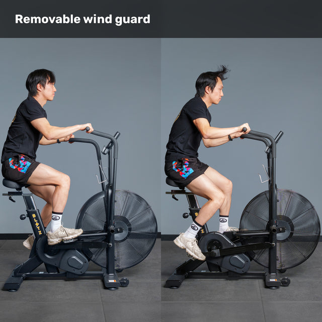 Side-by-side images of a man using the Bells of Steel Blitz Air Bike with and without its removable wind guard, showing his hair and shirt blown by the fan without the guard. Text at the top reads "Removable Wind Guard.