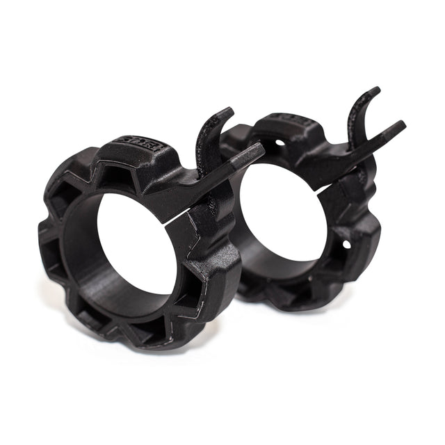 The Bells of Steel Barbell Zip Clips - Half Standard (Pair) are black plastic barbell clamps with gear-shaped edges and lever locks, designed to securely hold weight plates and ensure stability during intense workouts.