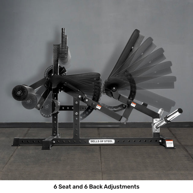 The Bells of Steel Legacy Leg Extension / Hamstring Curl Machine – Plate Loaded is displayed against a gray wall and black floor, showcasing its adjustable design—ideal for home gyms. The "BELLS OF STEEL" label is visible on the machine.