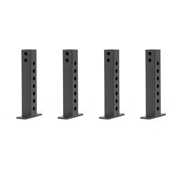 Four black, rectangular metal brackets with circular holes are evenly spaced against a white background. These connectors, the Folding Rack Wall Connectors & Hinges by Bells of Steel, have a flat base for mounting and are compatible with Hydra & Manticore racks.