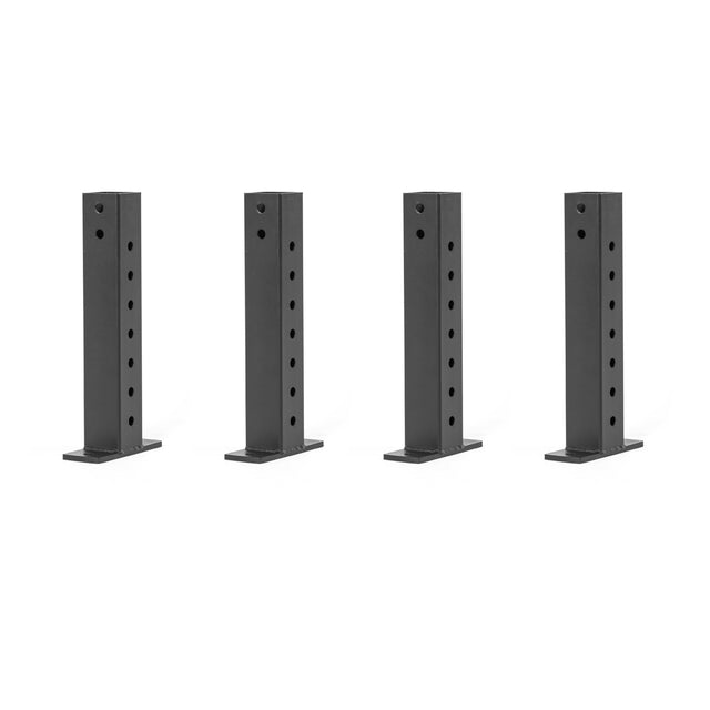 Four Bells of Steel Folding Rack Wall Connectors, crafted from black metal with multiple holes, are laid out on a white background. These rectangular brackets have a flat base, making them ideal for mounting and support—perfect for Hydra racks needing precision and durability.