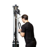 A man in a black t-shirt uses the Bells of Steel 2 to 1 Cable Attachment Adapter for exercise, viewed from the back against a white background.
