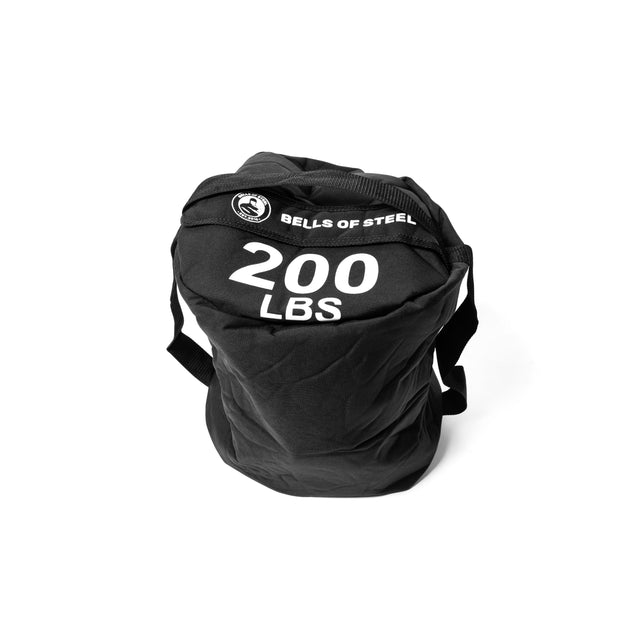 A cylindrical black fitness sandbag labeled "200 LBS" features the "Bells of Steel" logo prominently on top. Constructed from durable Condura material, this sandbag includes sturdy straps and is presented against a plain white background, making it perfect for intense workouts.