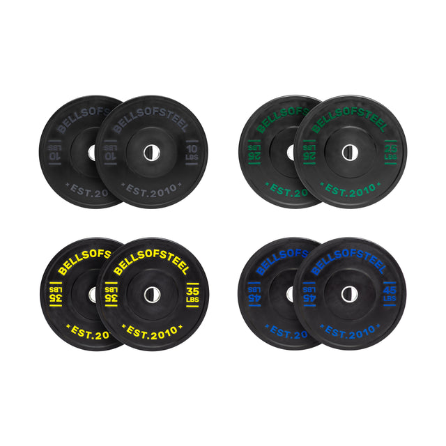 The Dead Bounce Conflict Bumper Plates by Bells of Steel include four pairs: 10 lbs, 15 lbs, 35 lbs, and 45 lbs. Each pair features virgin rubber with colored text (white, green, yellow, blue) for weight and brand identification. They have durable construction with a stainless steel insert for longevity.