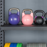 Three kettlebells rest on the Bells of Steel Storage Shelves, with colorful weight plates organized below. The shelf and background wall are gray.