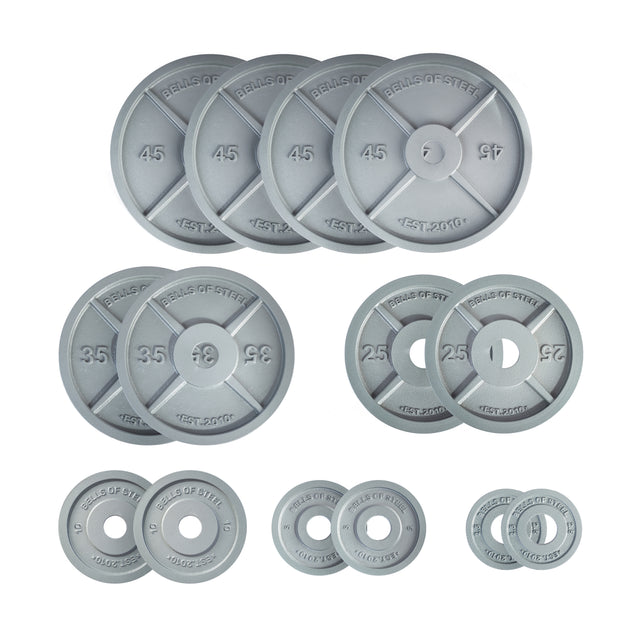 Image showcasing multiple Machined Iron Olympic Weight Plates by Bells of Steel, arranged in descending size. Each plate prominently displays its weight in large numbers, ranging from 45 to 2.5 pounds, with the brand "Bells of Steel" etched into the metal. These sleek plates feature a precision hole for optimal performance.