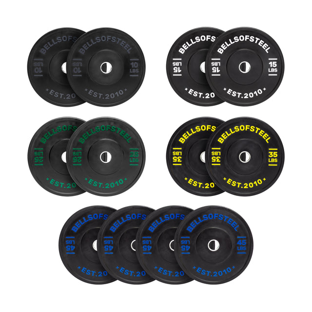 The Dead Bounce Conflict Bumper Plates set by Bells of Steel includes 16 plates: two 10 lbs (black), four 15 lbs (green), four 25 lbs (yellow), and four 45 lbs (blue). Crafted from virgin rubber with stainless steel inserts, each plate is labeled "BellsofSteel *EST. 2010*".