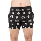 A person is wearing black Gym Shorts by Bells of Steel, featuring white logos and circular designs. Made from durable, stretchy polyester, these lightweight shorts have a drawstring waist and a plain white backdrop.