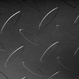 Close-up of a black metal surface with a repeating raised oval tread pattern, like that found on the Bells of Steel Footplate for Cable Tower/All In One Trainer, providing added grip and safety.