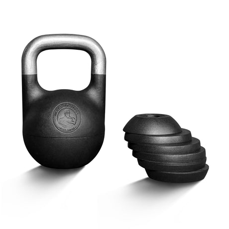 A Bells of Steel 6-12KG Adjustable Kettlebell in black, featuring a competition-style design with a metallic handle, stands upright beside its detachable weight plates—stacked by size on a white background—inspired by Mark Wildman’s training methods.
