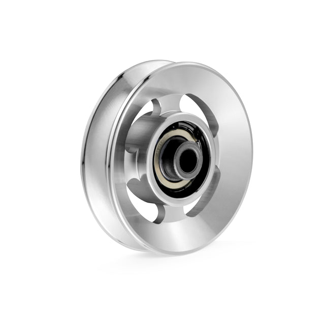 Close-up of a Bells of Steel Aluminum Pulley Wheel with a shiny silver finish against a white background. The central black core is encased by a polished, circular disk, creating an industrial yet sleek appearance.