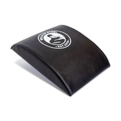 The Bells of Steel Sit Up Mat is a black ab mat featuring their white logo with a kettlebell and "Est. 2010" text. Its curved design provides excellent lumbar support, making it perfect for enhancing your core workout routine.