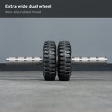 The Bells of Steel ABsyidyan Stainless Steel Ab Roller features an extra-wide dual wheel, non-slip rubber tread, knurled metal handles, and supports up to 500 lbs. Displayed resting on a gray floor.