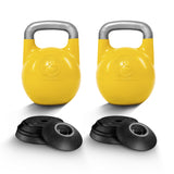 Two yellow Bells of Steel Adjustable Competition Kettlebells with silver handles, each featuring a front emblem, are displayed behind sets of black weight plates on a white background. Ideal for kettlebell training.