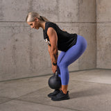 Female athlete doing squats using Adjustable Competition Kettlebell
