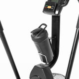 Close-up of a Bells of Steel Residential Air Bike with Wind Guard, featuring handlebars and a digital display for full-body workouts. A water bottle sits in its holder, with buttons on the console visible—ideal for any home gym.