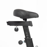 Close-up of an adjustable black Bells of Steel bike seat with scale markings numbered 1 to 3 on the post. Ideal for a Residential Air Bike with Wind Guard in your home gym, it is set against a plain white background, emphasizing its ergonomic design and adjustment knobs.