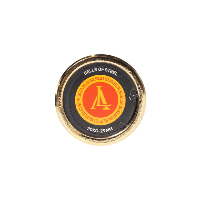 A round, gold-edged weight plate with a black center and red/yellow logo reading "BELLS OF STEEL" and "20KG-29MM," ideal for pairing with your Bells of Steel Alex Leonidas Onyx Bar on a white background.
