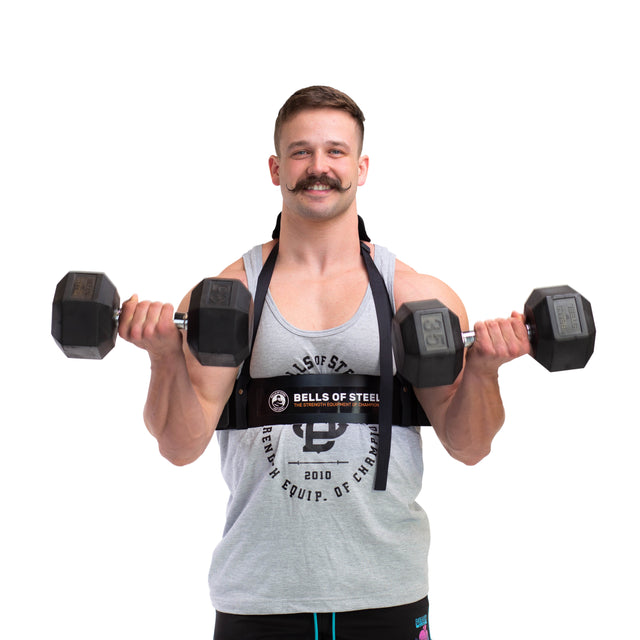 A person with a mustache is wearing a gray tank top and performing bicep curls using an Arm Blaster by Bells of Steel for proper form, all while smiling against a white background.