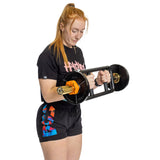 A woman with long red hair in a ponytail, dressed in a black t-shirt and shorts, holds a barbell secured with Bells of Steel Magnetic Clamp Collars against a white background.