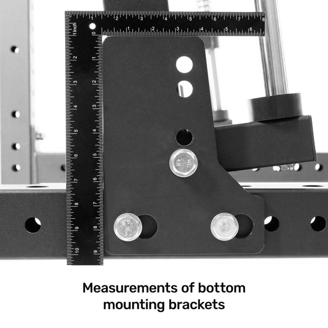 Close-up of black Bells of Steel Smith Machine Rack Attachment brackets with vertical and horizontal rulers. Three silver screws are visible. Text reads, "Measurements of bottom mounting brackets.