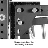 Close-up of black metal mounting brackets with bolts on the Bells of Steel Smith Machine Rack Attachment, featuring a ruler for scale. The image highlights precise measurements and structural details. Text below reads: "Measurements of top mounting brackets.