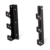 The Bells of Steel 3 Barbell Wall Rack, featuring two black, L-shaped metal brackets with multiple circular holes and protruding sections, serves as a wall-mounted barbell holder. Each bracket includes screws for installation and is lined with HDPE plastic to protect surfaces, elegantly positioned upright on a white background.