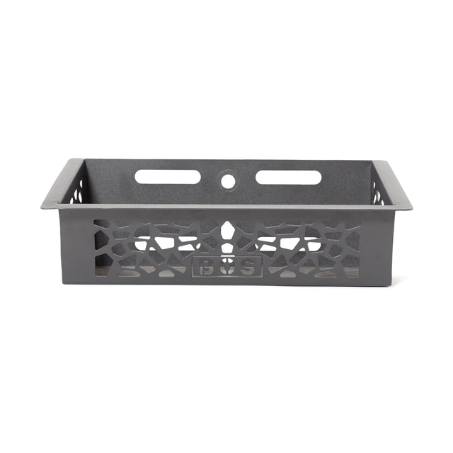 The Bells of Steel Rack Attached Storage Basket is a black rectangular metal basket with patterned cut-out sides, two horizontal slots, and a circular hole at the back—perfect for organizing gym or fitness accessories.