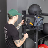 Male model putting gym equipment in the Rack Attached Storage Basket
