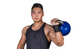 A muscular man sports Bells of Steel wrist wraps and a sleeveless black tank top while confidently holding a blue kettlebell over his shoulder, posing against a plain white background.