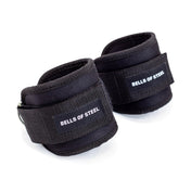 The Adjustable Ankle Strap Cable Attachment - Pair by Bells of Steel features black straps with white branding, padded support, adjustable Velcro closures, and a D-ring for glute training or weightlifting. Displayed against a plain white background.