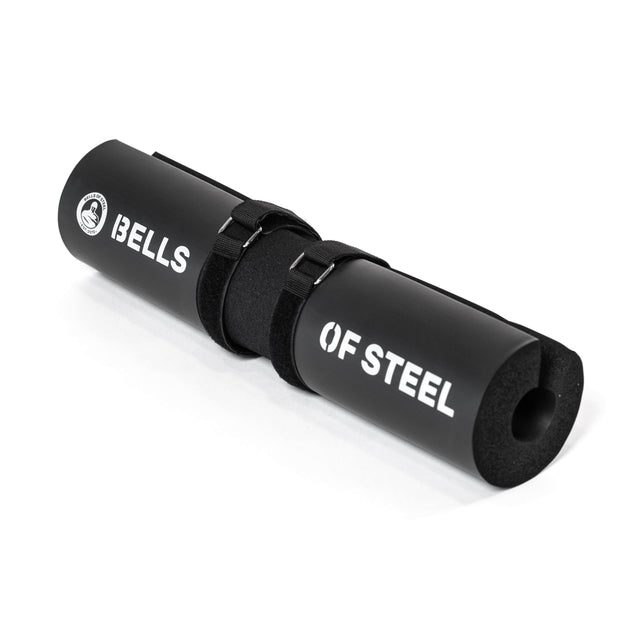 The Bells of Steel Barbell Pads with Straps features an ergonomic black foam design, white "BELLS OF STEEL" text, and includes two black straps for barbell attachment.