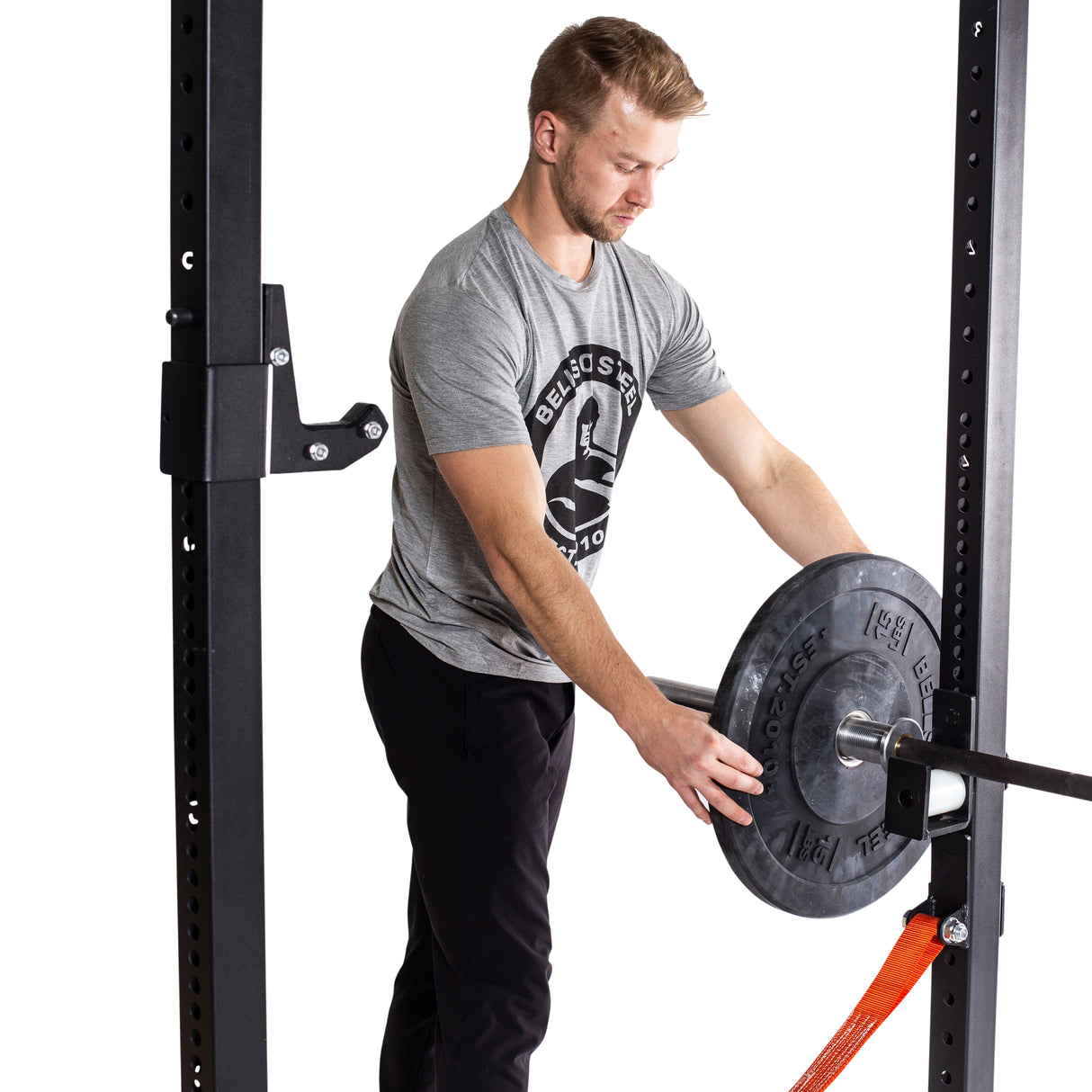 Male athlete putting All-Black Bumper Plates on barbell
