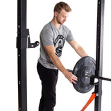 Male athlete putting All-Black Bumper Plates on barbell