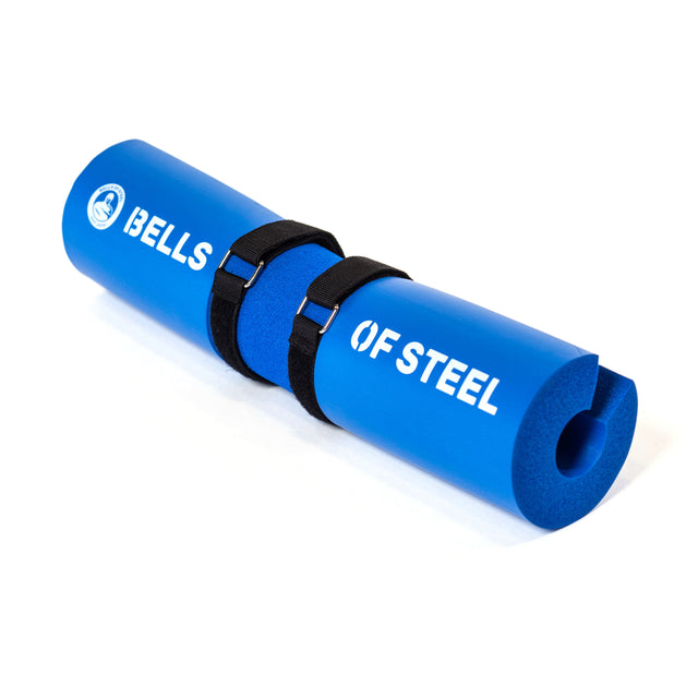 Bells of Steel blue foam barbell pad features an ergonomic design with two black straps and "BELLS OF STEEL" in white text.